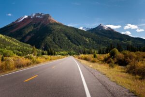 A road leading to the Colorado mountains during summer | Alpenglow Vacation Rentals Ouray