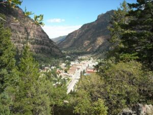 The city of Ouray seen through mountain trees | Alpenglow Vacation Rentals